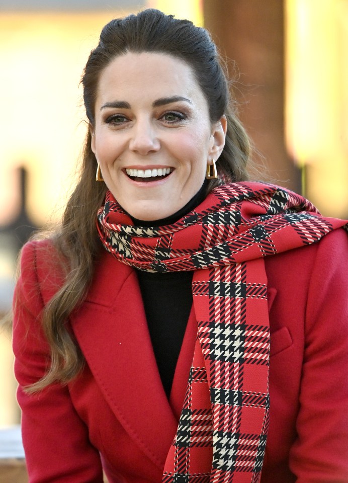 Kate wore gold earrings with a bright red Alexander McQueen jacket and a tartan scarf in Wales today