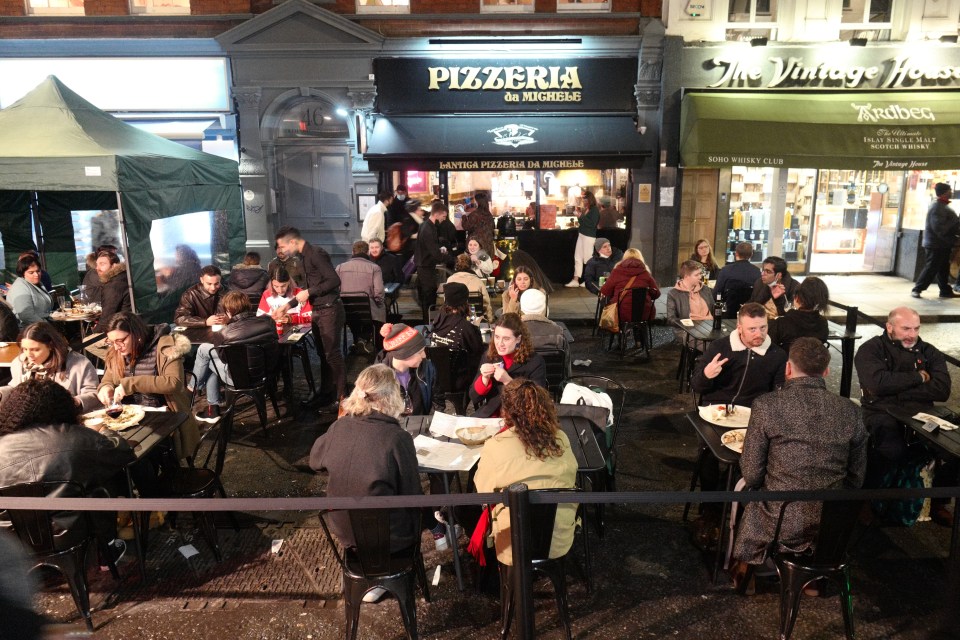 People put on their warmest coats and hats to sit outside and have a pizza