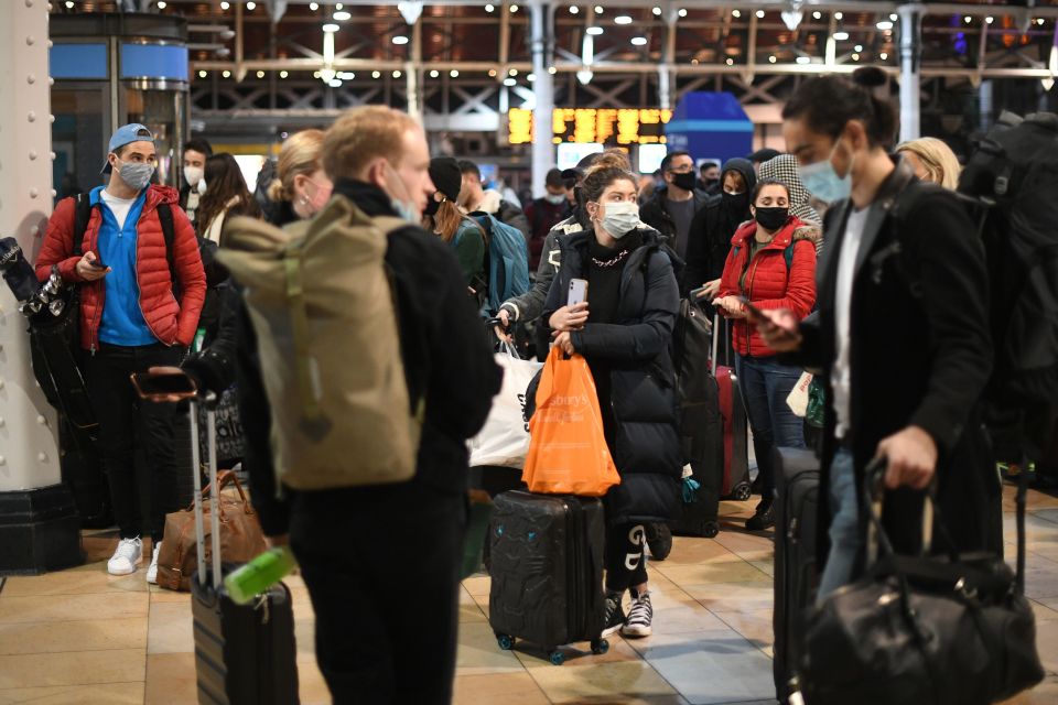 People wait for trains at a packed Paddington station