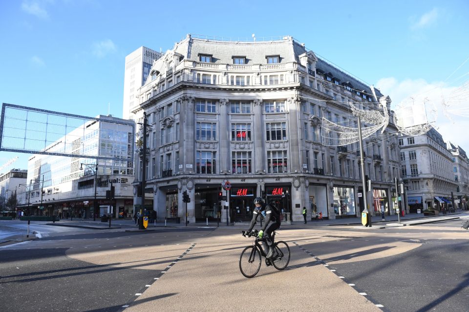 A lone cyclist pedals down across an empty Oxford Circus on Sunday