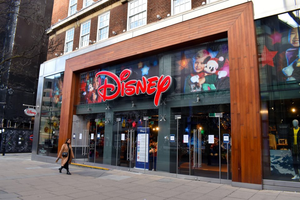 A woman walks past a closed Disney store