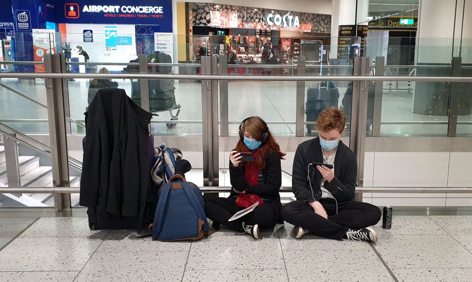 Two passengers are seen at a desolate Gatwick Airport as Brits fled the UK amid a travel ban