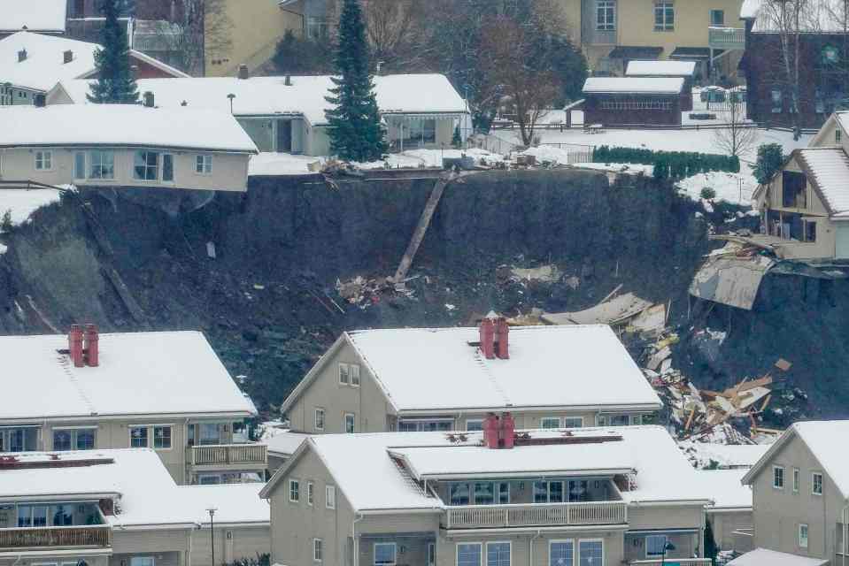 Destroyed houses are seen in a crater left behind by a landslide in the town of Ask