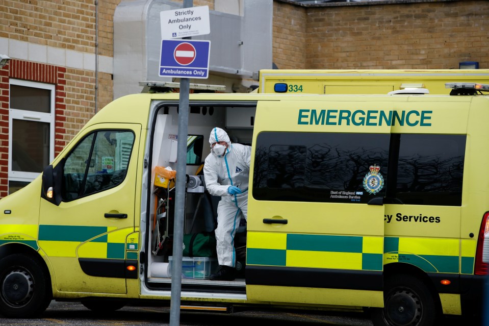 A healthcare worker wearing PPE gets out of the ambulance outside Southend University Hospital