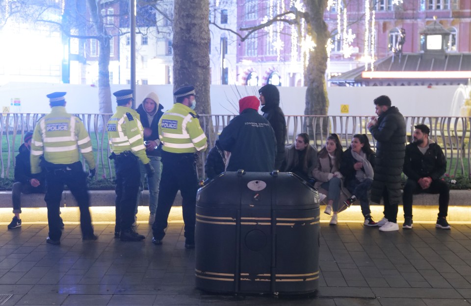 Cops speak to a group of people in Leicester Square in London