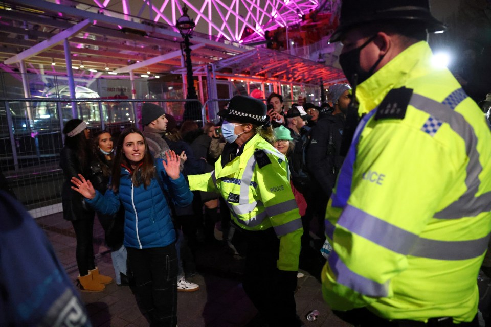 Cops speak to a woman in London during New Year's celebrations