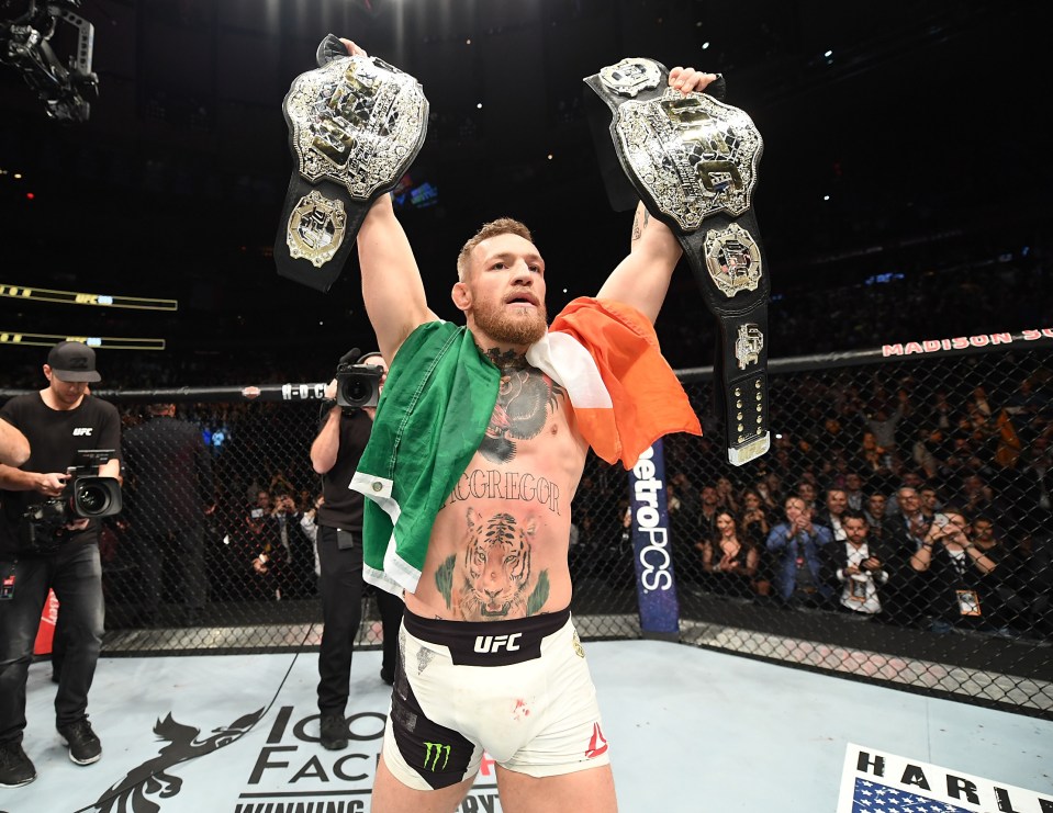 McGregor holds aloft his featherweight and lightweight belts after defeating Alvarez in 2016