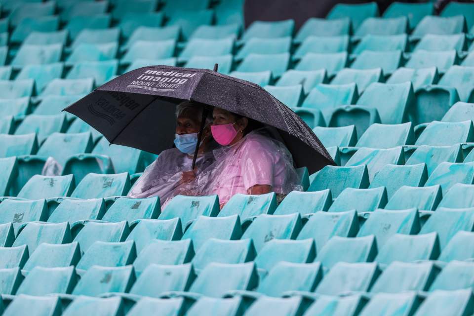 Fans took shelter during a break in play for rain