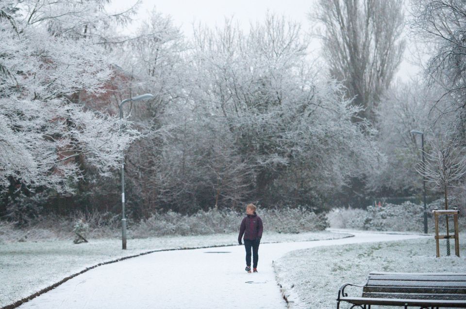 People walk through the snow-covered St Nicholas' Park, in Warwick