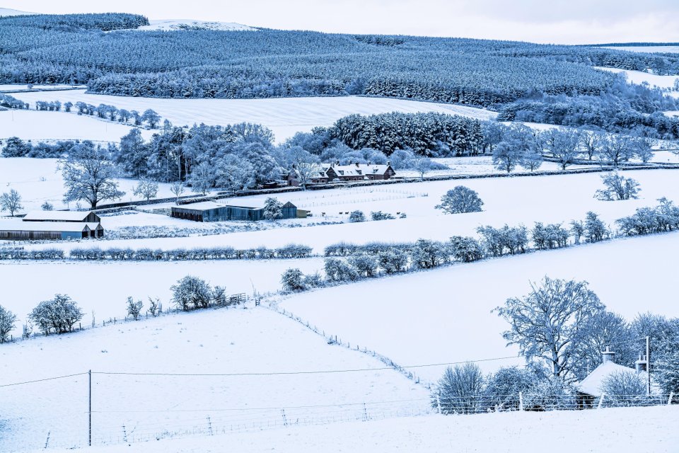 A snow blanketed landscape at Oxnam village south of Jedburgh in the Scottish Borders