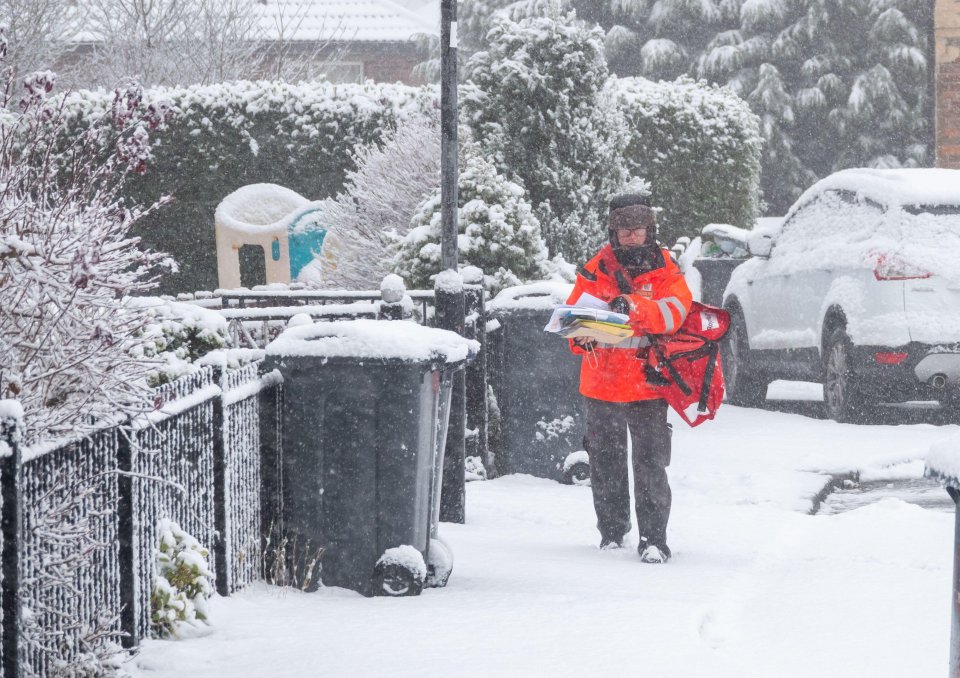 A postman bravely trudges through the snow this morning