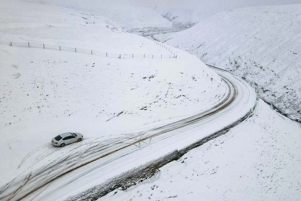 Cars take on the difficult conditions on the A57 Snake Pass in the Peak District 