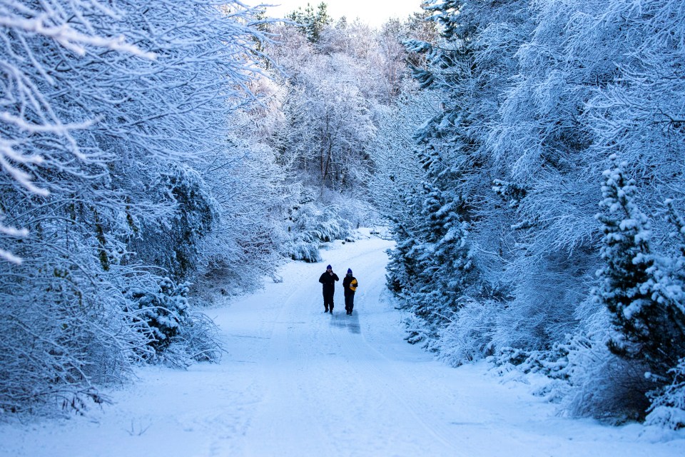 People walk through a snowy scene in the Pentlands near Edinburgh