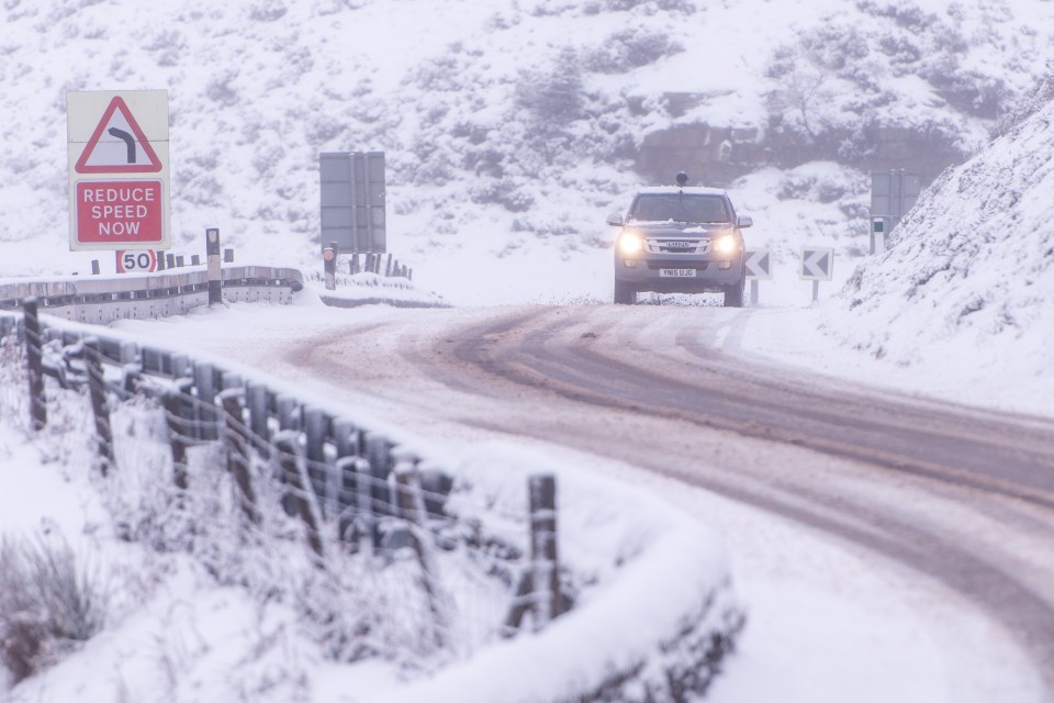 Cars drive through difficult conditions on the A57 Snake Pass