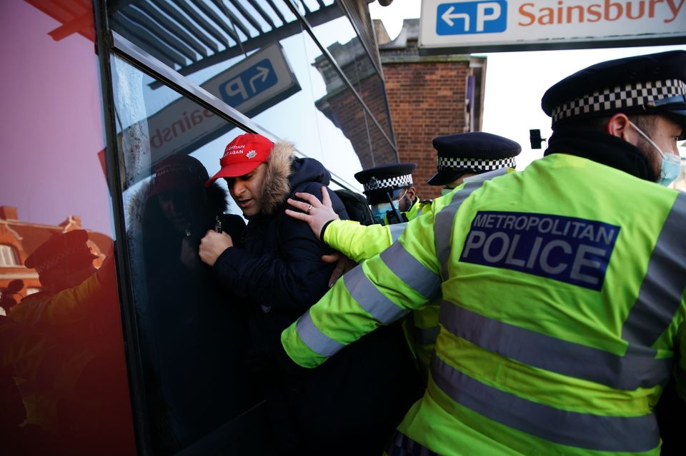 A man is held to the wall for breaking Covid restrictions - with one bystander yelling 'idiot'