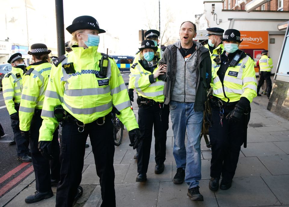 A man is led away from the protest