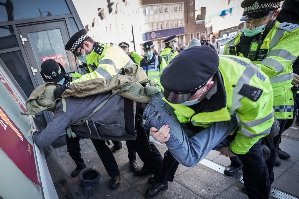 One man is taken to the ground by masked officers