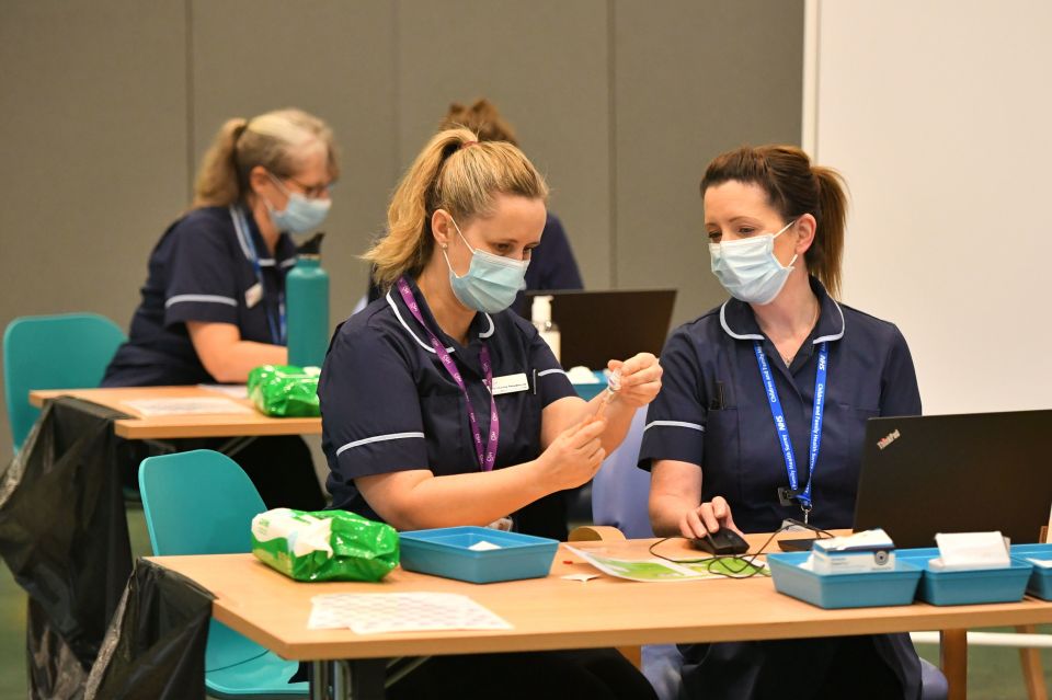 NHS staff are seen preparing for a busy day ahead at a vaccine centre at Epsom Race Course in Surrey 