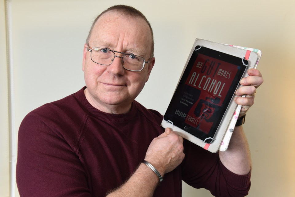 Nick holds up the e-book of My Gut Makes Alcohol!: The Science and Stories of Auto-Brewery Syndrome by Barbara Cordell