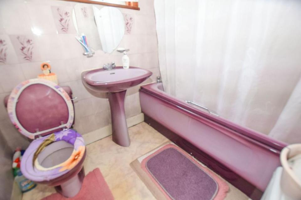 The purple bathroom was described as a 'nightmare', with its colourful bath, basin and toilet