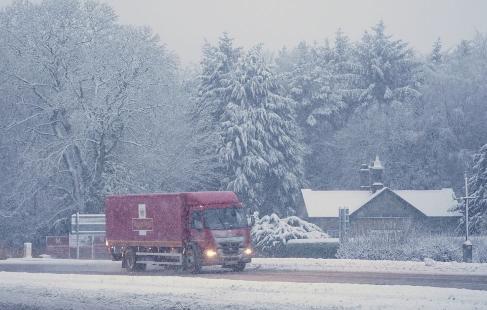 A Royal Mail lorry drives through snow on the A69 near Newcastle