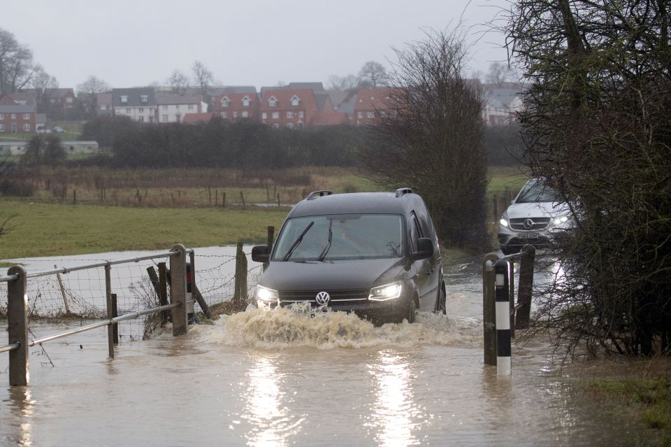 Cars pass through a flood along Hamilton Road in Leicester