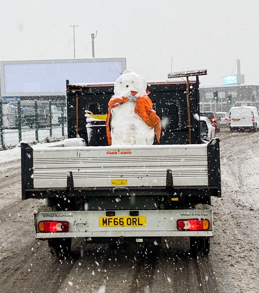 Builders give snowman a lift on the back of their van in Leeds