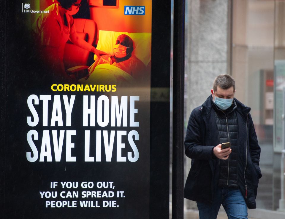 A man passes a government coronavirus advert in central London 