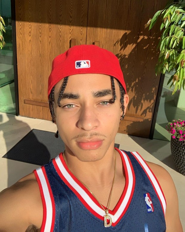 a young man wearing a red hat and a nba jersey