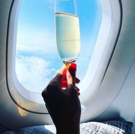 Her most recent post was of her holding a champagne glass on a flight abroad