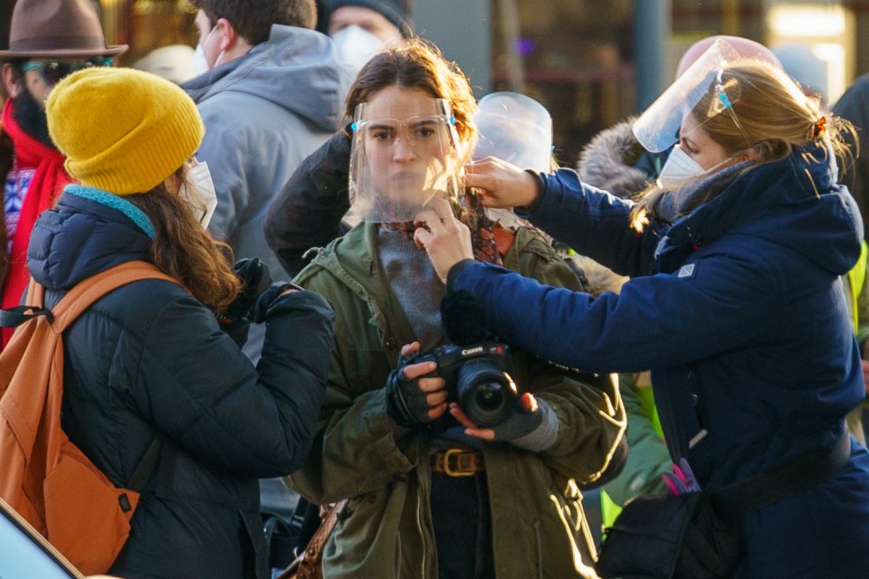 The actress donned a plastic visor while on set