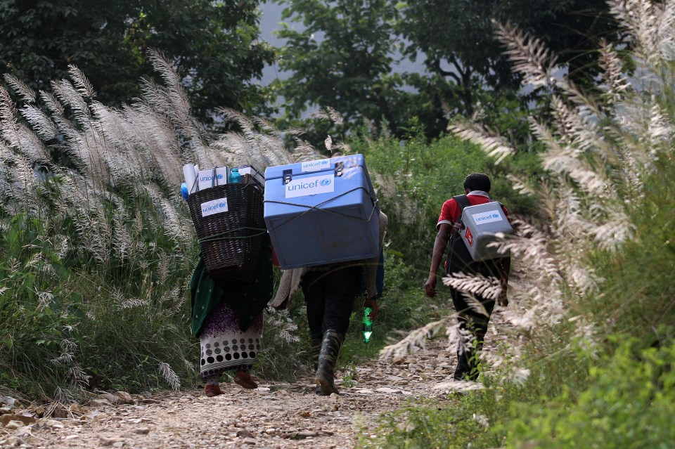 Health workers carry vaccines en route to a measles, rubella and polio vaccination campaign in Gorkha District in 2015