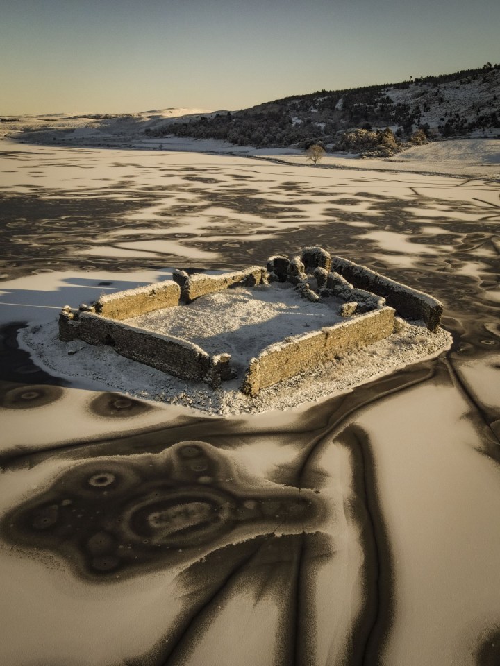 The ruins of the 13th century Lochindorb Castle in the middle of its icy loch  near Nairn in the Scottish Highlands