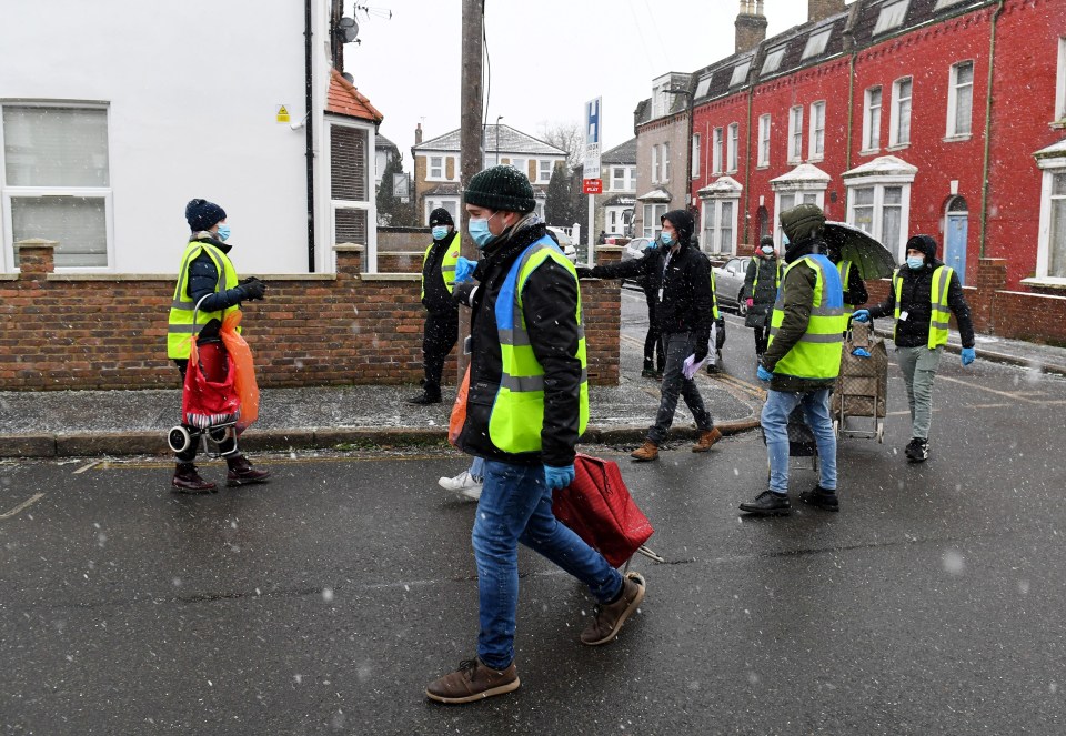 Council workers with testing kits in a residential street of Ealing, taking part in a mass door-to-door testing programme