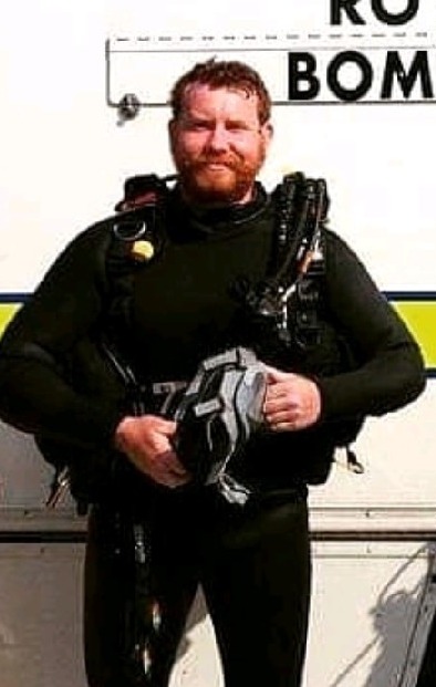 Navy diver Jon Finlay has been demoted after undoing his trousers in front of a junior female colleague