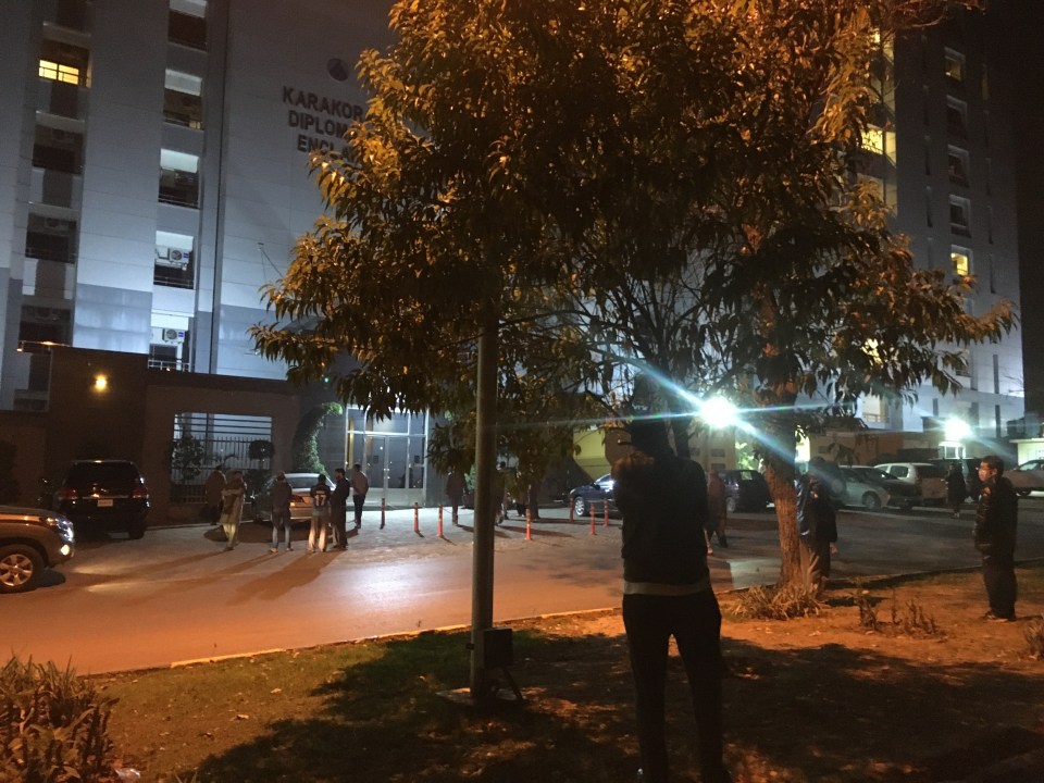 Residents gather outside a building in Islamabad following the quake