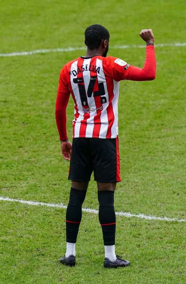 Josh Dasilva raises his right fist as Brentford players decided not to take a knee