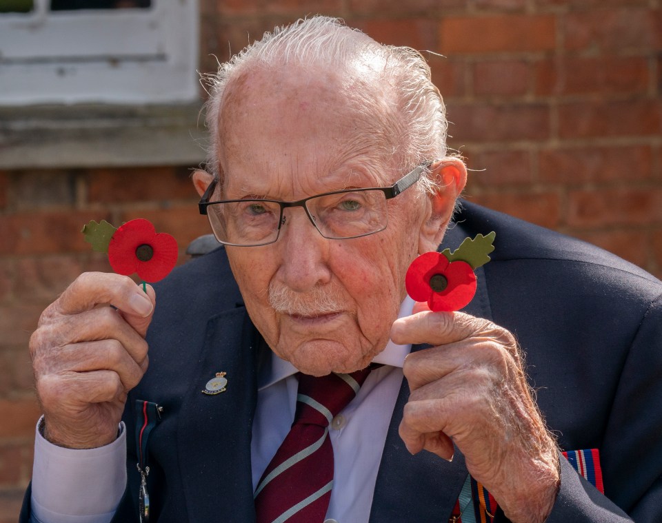 Captain Tom Moore holds two poppies showing his support for the British Legion