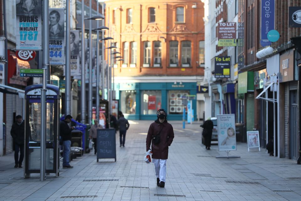 A man walks down a quiet street in Belfast city centre as the six week lockdown in Northern Ireland continues