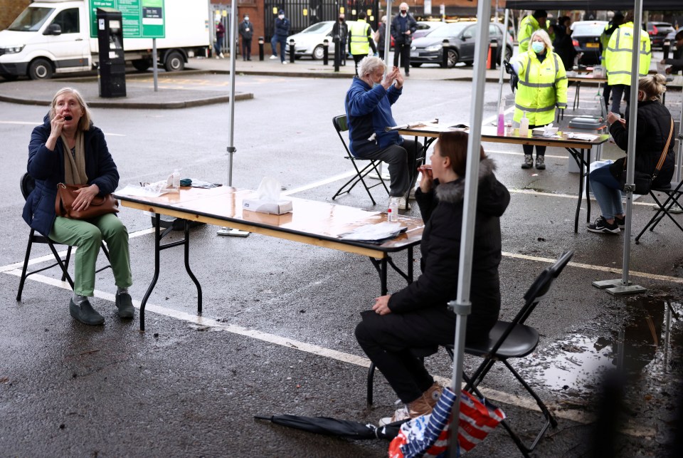 People take swab tests at a coronavirus testing site in Ealing, west London