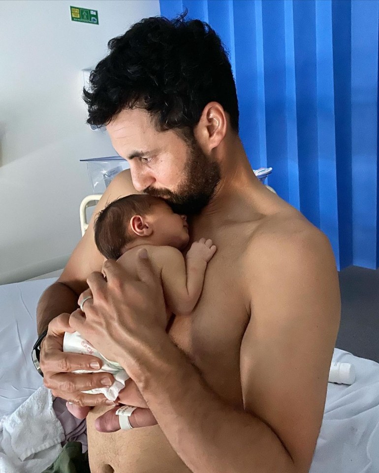 Cam holding Oliver after he was born