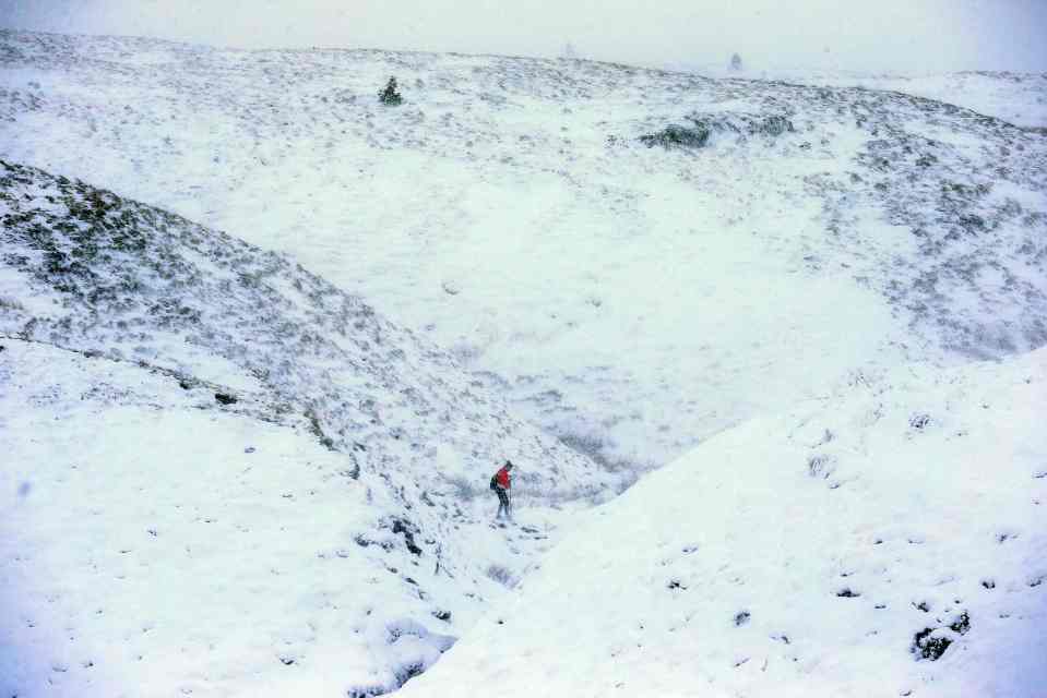 A walker braves the perilous icy conditions in Saddleworth, Greater Manchester