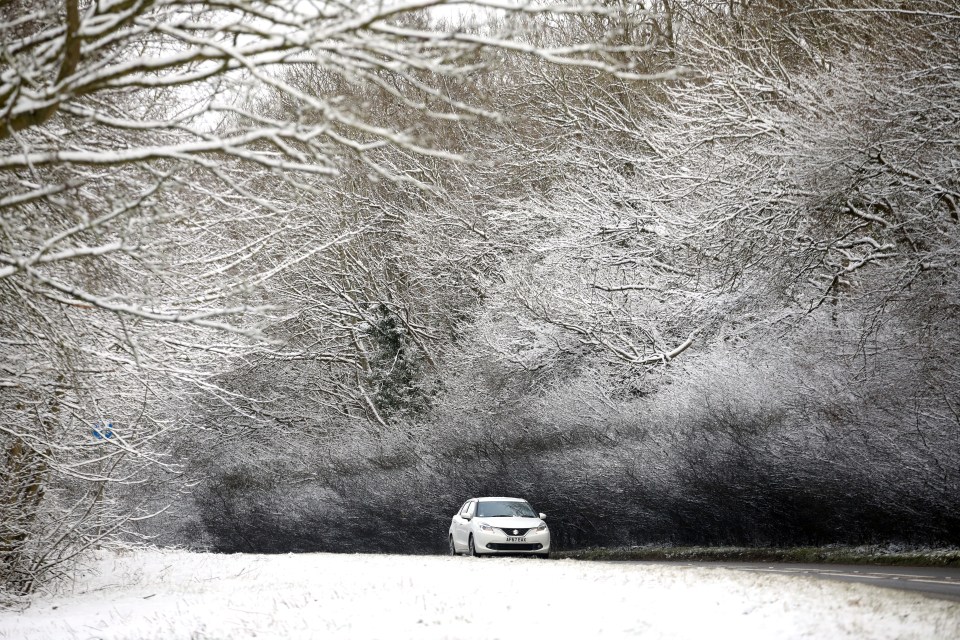 A car makes its way up a hill as heavy snow has fallen in Stamford, Lincolnshire