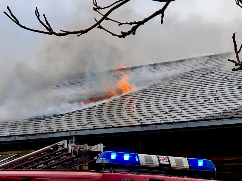 The blaze could be seen through the roof as smoke poured out