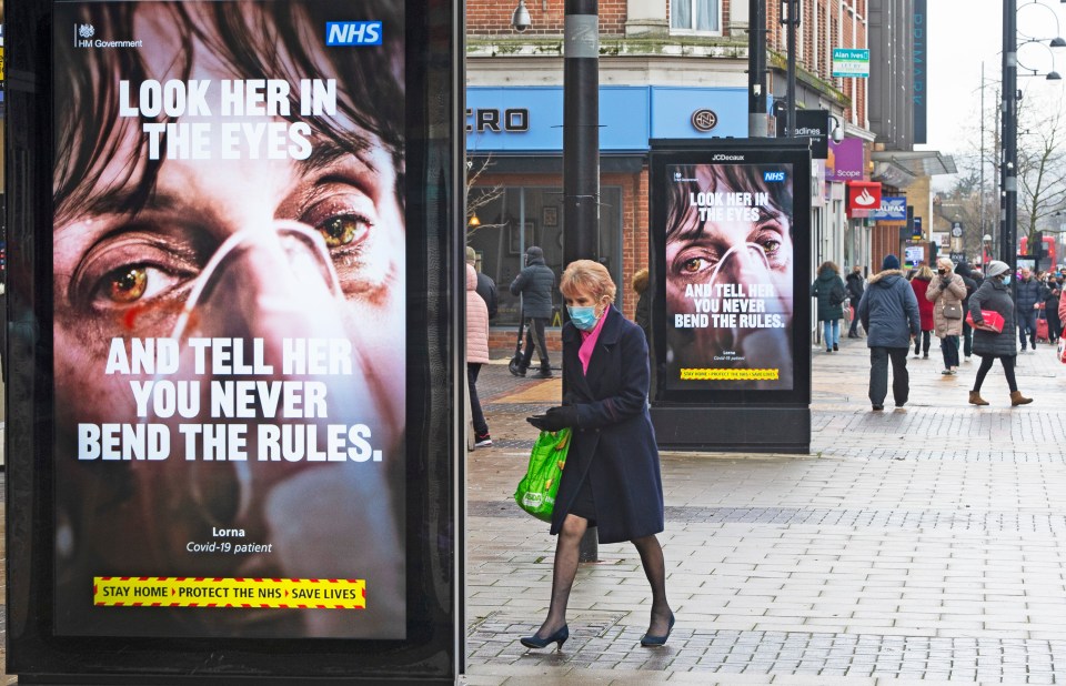 A woman wears a mask while walking through Bexleyheath, South East London today