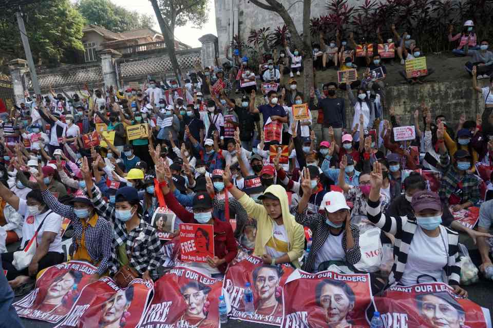 Protesters hold signs during a demonstration outside the US Embassy against the military coup in Yangon