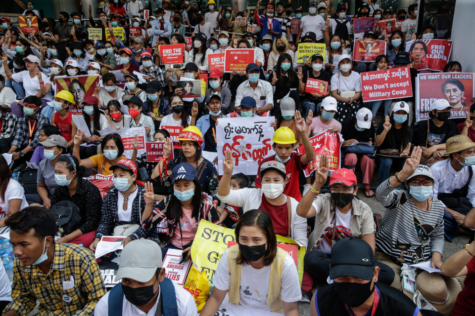 Demonstrators holding placards flash the three-finger salute during a protest in Yangon, Myanmar