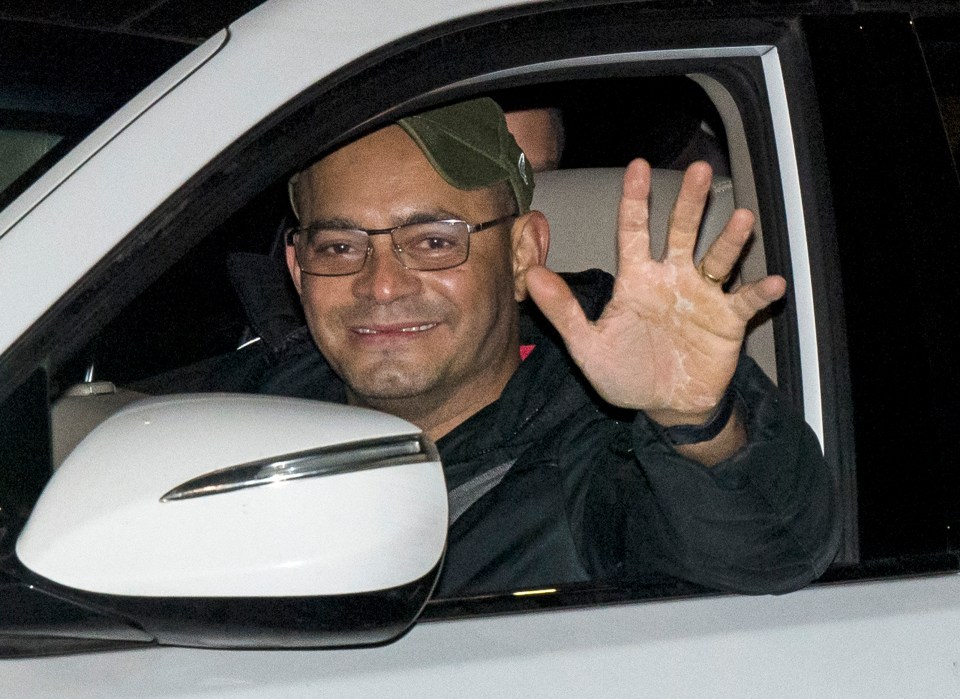 Mr Araujo waves from a car as the first travellers leave the Radisson hotel near Heathrow Airport