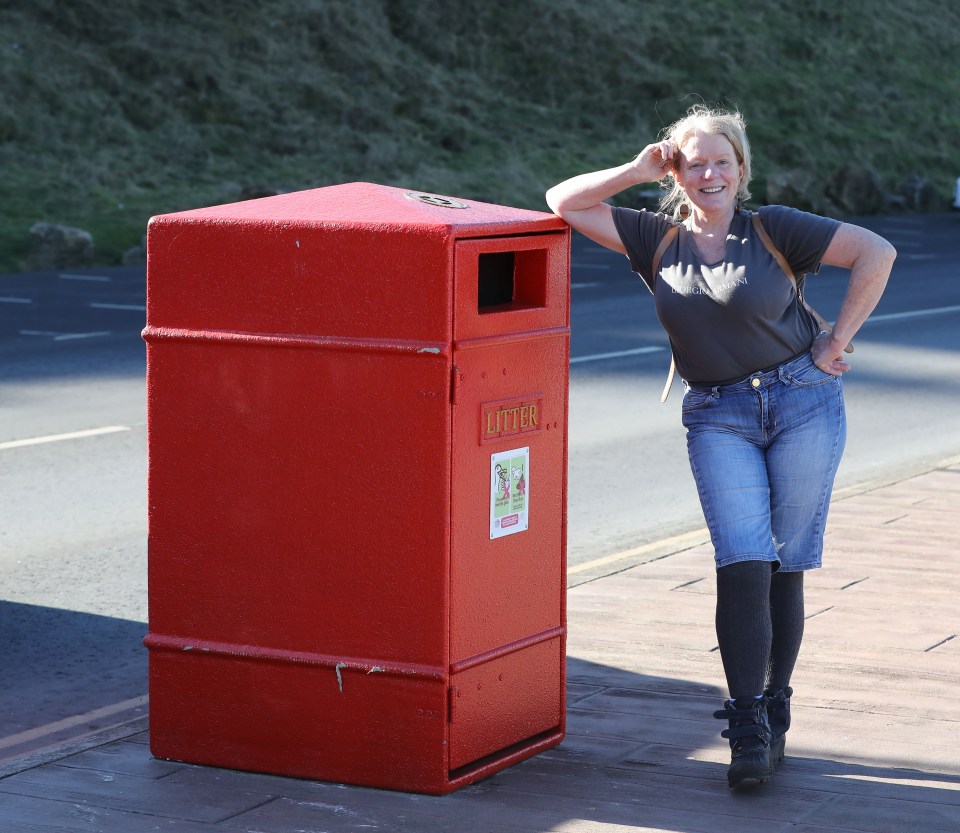 The metal trash cans have the word 'Litter' in gold Post Office script plus letter box-style slots