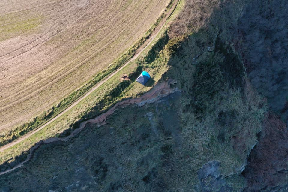 A couple have been slammed for camping on the edge of a cliff with a young child